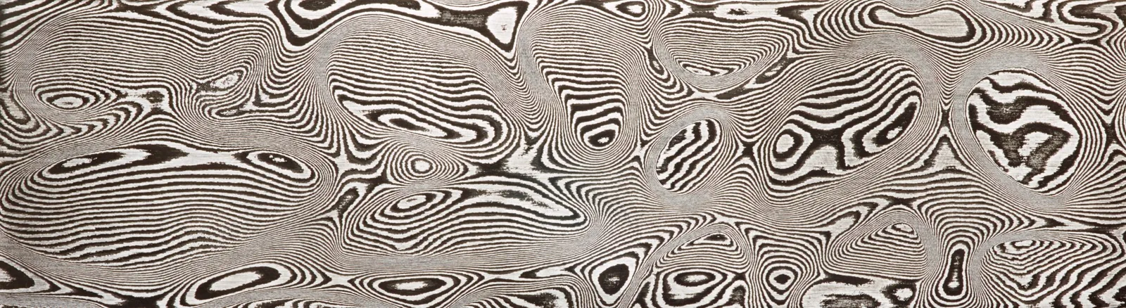 A bar of DSC Carbon Damascus etched to a flowing Leopard pattern